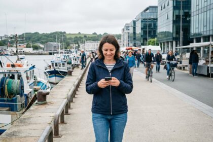 Femme marchant dans le port de Brest avec smartphone